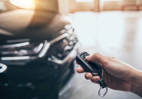 Hand presses unlock on the car remote control.